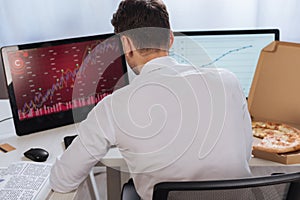 businessman sitting near computers with charts