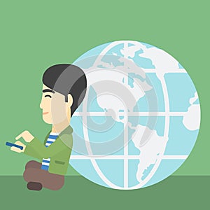 Businessman sitting near Earth globe.