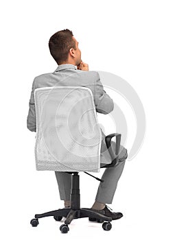 Businessman sitting in office chair from back