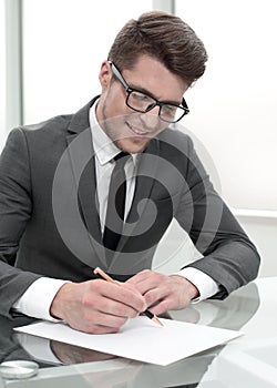 Businessman sitting at office desk signing a contract