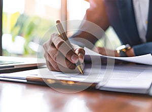 Businessman sitting at office desk signing a contract close up