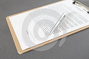 Businessman sitting at office desk signing a contract with shallow focus on signature