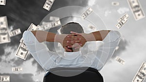 Businessman sitting outside while dollars fall down.