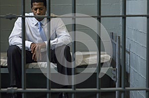 Businessman Sitting In Prison Cell