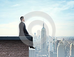 Businessman sitting on roof