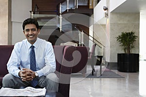 Businessman Sitting On Sofa In Hotel Lobby