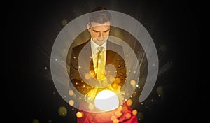 Businessman sitting with sparkling magic ball