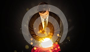 Businessman sitting with sparkling magic ball