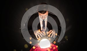 Businessman sitting with sparkling magic ball