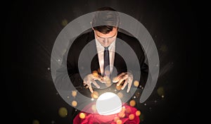 Businessman sitting with sparkling magic ball