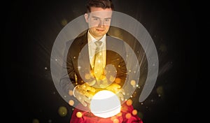 Businessman  sitting with sparkling magic ball
