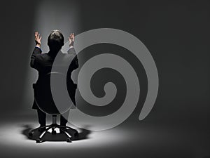 Businessman Sitting In Spotlight