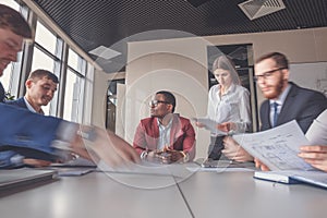 Businessman sitting at table with working blurred people on background.