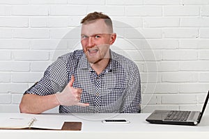 Businessman sitting at the table and working on the computer. It solves important business tasks. He is successful and well-traine