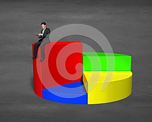 Businessman sitting on top of 3d pie chart