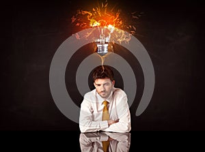 Businessman sitting under a blowing idea bulb
