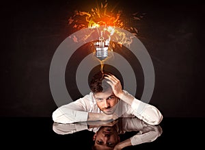 Businessman sitting under a blowing idea bulb