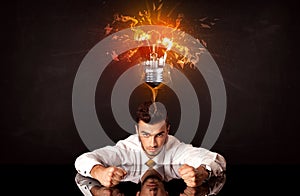 Businessman sitting under a blowing idea bulb