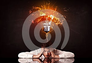 Businessman sitting under a blowing idea bulb