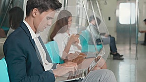 Businessman sitting using laptop computer working on the subway train