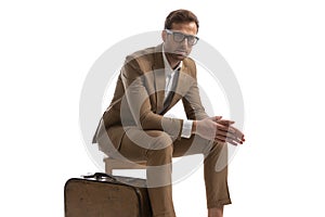 Businessman sitting on a wooden chair, holding his hands together