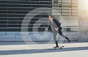 Businessman on a skateboard in urban area