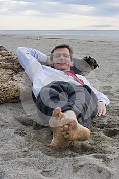 Businessman sleeping on a beach