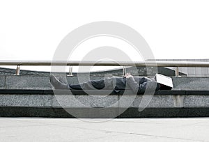 Businessman sleeping on the bench with a book covering his face. Conceptual image shot