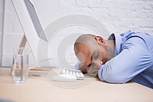 Businessman sleeping by computer at desk