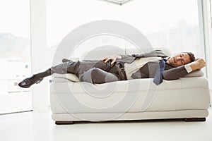Businessman sleeping on couch in living room