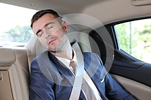 Businessman sleeping in a taxi