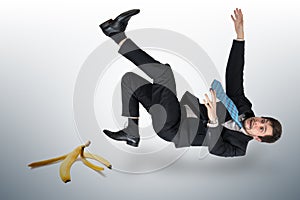Businessman slipping on a banana peel photo