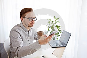 Businessman with smarphone and coffee at office