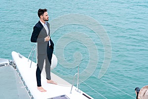 Businessman with smart phone on cruise yacht with background of sea and white sky. Concept business travel