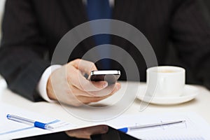 Businessman with smartphone reading news