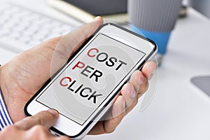 Businessman with a smartphone with the text cost per click