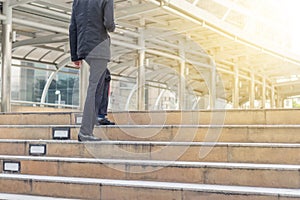 Businessman with smartphone walking up stairs to office