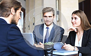 Businessman smiling happily as his business partner finally signing important contract.