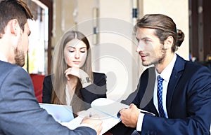 Businessman smiling happily as his business partner finally signing important contract.