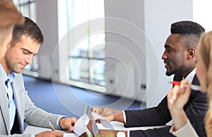 Businessman smiling happily as his business partner finally signing important contract.