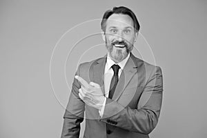 Businessman smiling mature man pointing copy space, promoting services concept