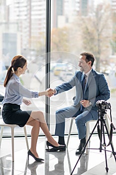 Businessman shaking hand of his journalist and smiling after good talk