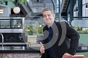 Businessman smiling showing thumbs up. The Portrait of Cheerful Businessman showing Thumbs Up