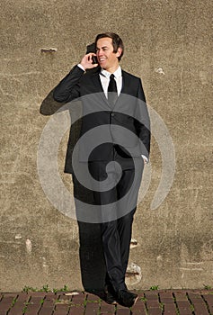 Businessman smiling and talking on mobile phone outdoors