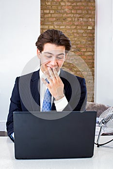 Businessman snickering at his laptop