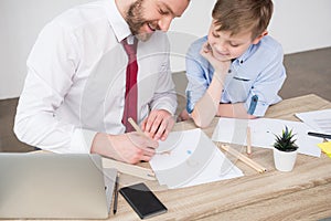 Businessman with son drawing at table