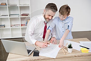 Businessman with son drawing at table