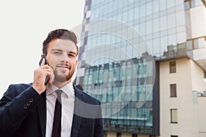 Businessman speaks on the phone outdoors