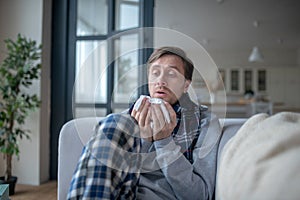 Businessman spending day at home wearing scarf while having flu