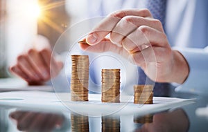 Businessman stacking coins on table, business growth concept. Hand puts coin to stack.